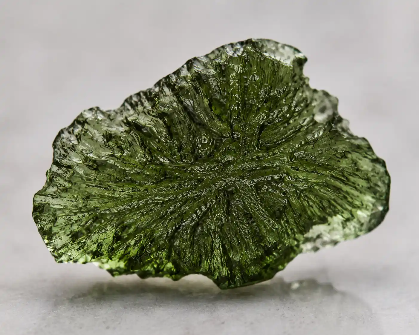 a forest-green moldavite tektite with etched surface