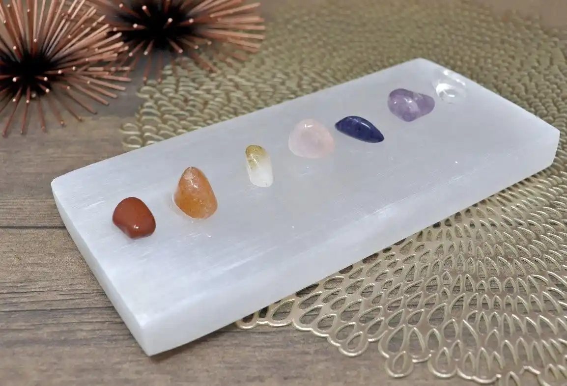 healing crystals resting on a polished selenite charging plate used for crystal cleansing