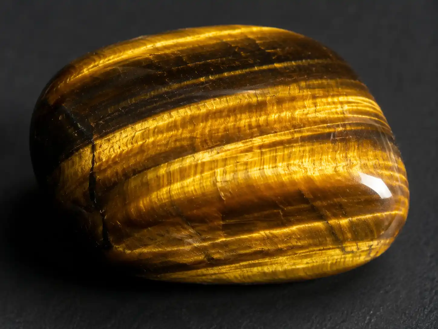 a polished tiger's eye stone showing golden chatoyant bands