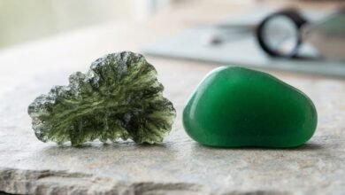 textured natural moldavite beside a smooth green glass imitation